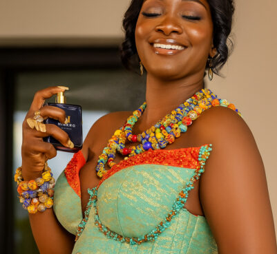 Bride wearing Kente accessories and holding Hinkro Moonlight perfume