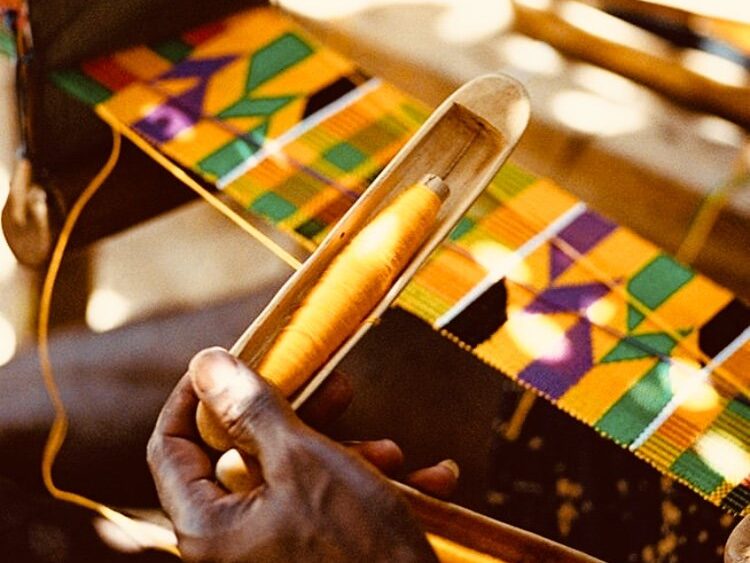 Skilled Kente weaver working on a traditional loom